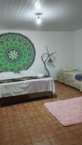 a bedroom with a bed with a green design on the wall at Pousada Raizes de Lencóis in Lençóis