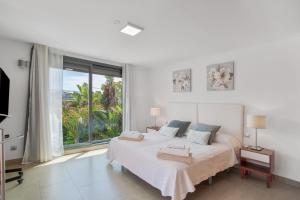 a white bedroom with a large bed and a large window at Alexandria's Retreat in San Bartolomé +18 photos