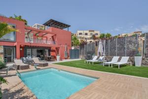 a swimming pool with lounge chairs and a house at Alexandria's Retreat in San Bartolomé