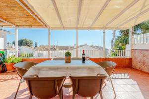 a table with chairs and a bottle of wine on a patio at Casa Pepe junto al mar in Benajarafe
