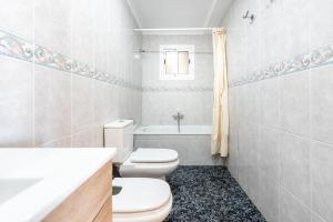 a white bathroom with a toilet and a sink at Casa Pepe junto al mar in Benajarafe +17 photos