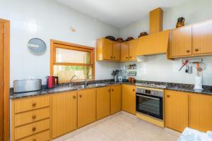 a kitchen with wooden cabinets and a sink at Sa Marina in Alcudia +17 photos