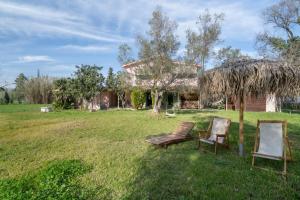 a yard with two chairs and a house at Lefkadas Bohemian Cottage in Lefkada