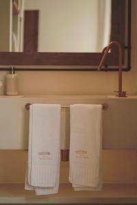 two towels hanging on a towel rack in a bathroom at M Villa Comporta Retreat in Carvalhal +37 photos