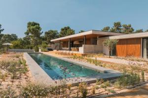 a swimming pool in front of a house at M Villa Comporta Retreat in Carvalhal