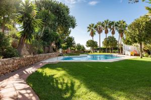 a swimming pool in a yard with palm trees at Mijas la Nueva in Mijas