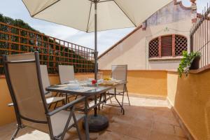 a table and chairs with an umbrella on a patio at Sauc Beach Apartment in Canet de Mar