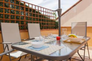 a glass table with bowls of fruit on it at Sauc Beach Apartment in Canet de Mar +13 photos