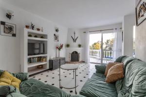 a living room with a green couch and a fireplace at Villa Nerja in Nerja