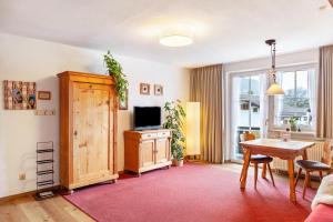 a living room with a table and a television at Ferienwohnung Zugspitzblick in Farchant