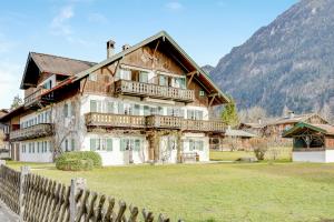 a large wooden house with a fence in front of it at Ferienwohnung Zugspitzblick in Farchant