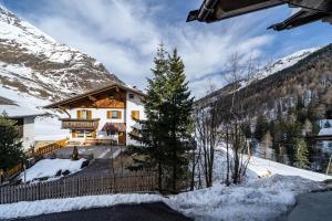 a house in the mountains with snow on the ground at Seppnerhof Ferienwohnung Edelweiss in Moso