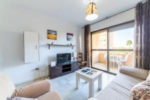 a living room with a couch and a tv at Apartamento Calle Ciruelo in Aguadulce
