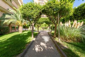 a path in a park with trees and a building at Apartamento Calle Ciruelo in Aguadulce