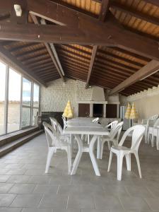 a dining room with white tables and white chairs at Chez Bilhouet in Segonzac