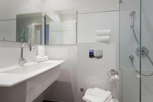 a white bathroom with a sink and a shower at Appartement Halbinsel Wittow in Binz