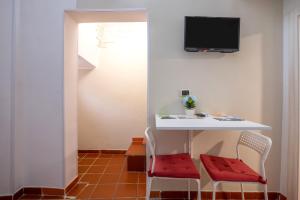 a room with a table and two chairs and a tv at Sg Apartment Standard in Massafra