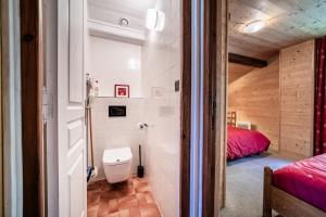 a bathroom with a toilet and a bed in a room at Chalet Arnica in Morzine +55 photos