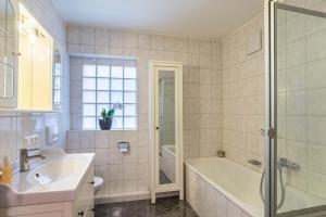 ein Badezimmer mit Badewanne, Waschbecken und Dusche in der Unterkunft Aposto Apartments 2 in Oberderdingen + 20 Fotos