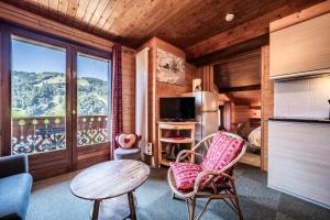 a living room with a table and chairs and a large window at Chalet Arnica in Morzine