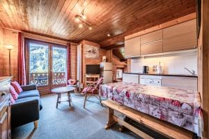 a bedroom with a bed and a kitchen with a table at Chalet Arnica in Morzine
