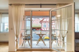 ein Zimmer mit Blick auf einen Balkon mit Glasschiebetüren in der Unterkunft Aposto Apartments 2 in Oberderdingen