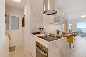 a white kitchen with a sink and a stove at Salitre Suites Tamara in Tacoronte +13 photos