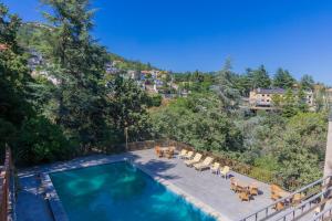 a swimming pool with tables and chairs on a balcony at Espacio Rural La Cabaña de Miraflores in Miraflores de la Sierra