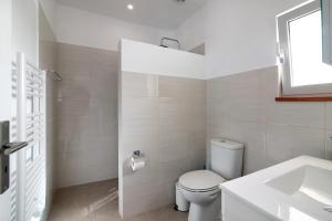 a white bathroom with a toilet and a sink at Adelino Guest House in Olhão +19 photos