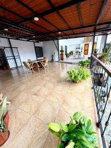 a large room with a table and chairs and plants at Hotel Nivel 5 in Macas