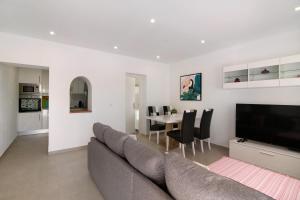 a living room with a couch and a table with chairs at Adelino Guest House in Olhão