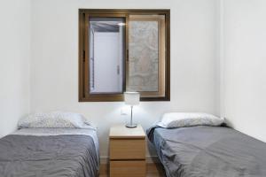 a bedroom with two beds and a mirror at Suite Deluxe Puerto Rico 11 in Puerto Rico de Gran Canaria +19 photos