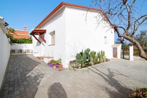 a white house with a brick driveway at Adelino Guest House in Olhão