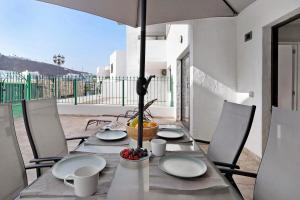 a table with chairs and an umbrella on a patio at Suite Deluxe Puerto Rico 11 in Puerto Rico de Gran Canaria