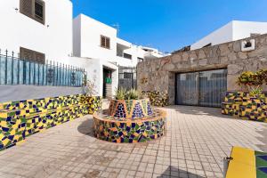 a courtyard with colorful vases in front of a building at Suite Deluxe Puerto Rico 11 in Puerto Rico de Gran Canaria