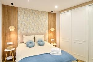 a bedroom with a bed with two blue pillows at El Mirador de Neptuno in Priego de Córdoba