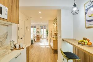 a kitchen with white cabinets and a counter with a bowl of fruit at El Mirador de Neptuno in Priego de Córdoba