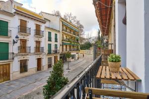 a balcony with a wooden bench on a city street at El Mirador de Neptuno in Priego de Córdoba
