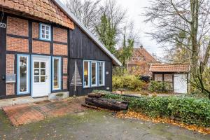 a black house with a white door and a yard at Alter Laden in Nienstädt