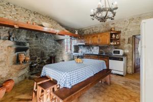 a kitchen with a table with a blue and white checkered table cloth at Quinta Das Regadas in Rendufe