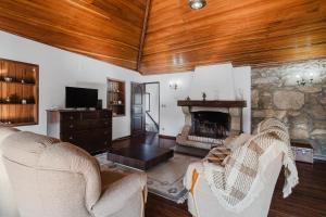 a living room with two chairs and a stone fireplace at Quinta Das Regadas in Rendufe