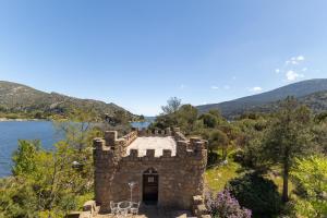 an old stone building next to a body of water at Isla Del Burguillo in Ávila