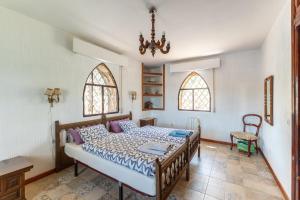 a bedroom with a bed and two windows at Isla Del Burguillo in Ávila
