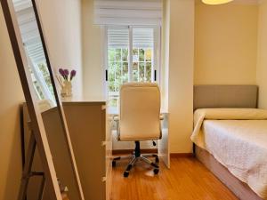 a bedroom with a desk and a chair next to a bed at Comodidad cerca del centro Granada in Albolote