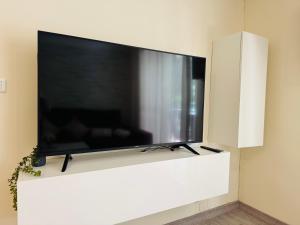 a large flat screen tv on a white wall at Comodidad cerca del centro Granada in Albolote