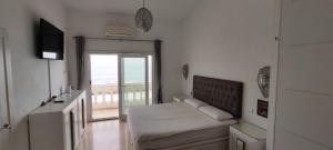 a room with a bed and a television and a balcony at Beach House El Saladillo in Estepona