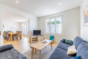 a living room with a blue couch and a table at Maison Familliale Centre Fromentine in La Barre-de-Monts