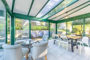 a conservatory with a table and chairs and glass windows at Maison Familliale Centre Fromentine in La Barre-de-Monts