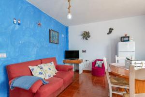 a living room with a red couch and a blue wall at La Caletilla La Graciosa in Caleta de Sebo
