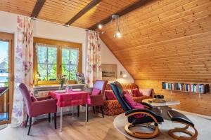 a living room with a couch and a table and chairs at Haus Leufke in Lenzkirch